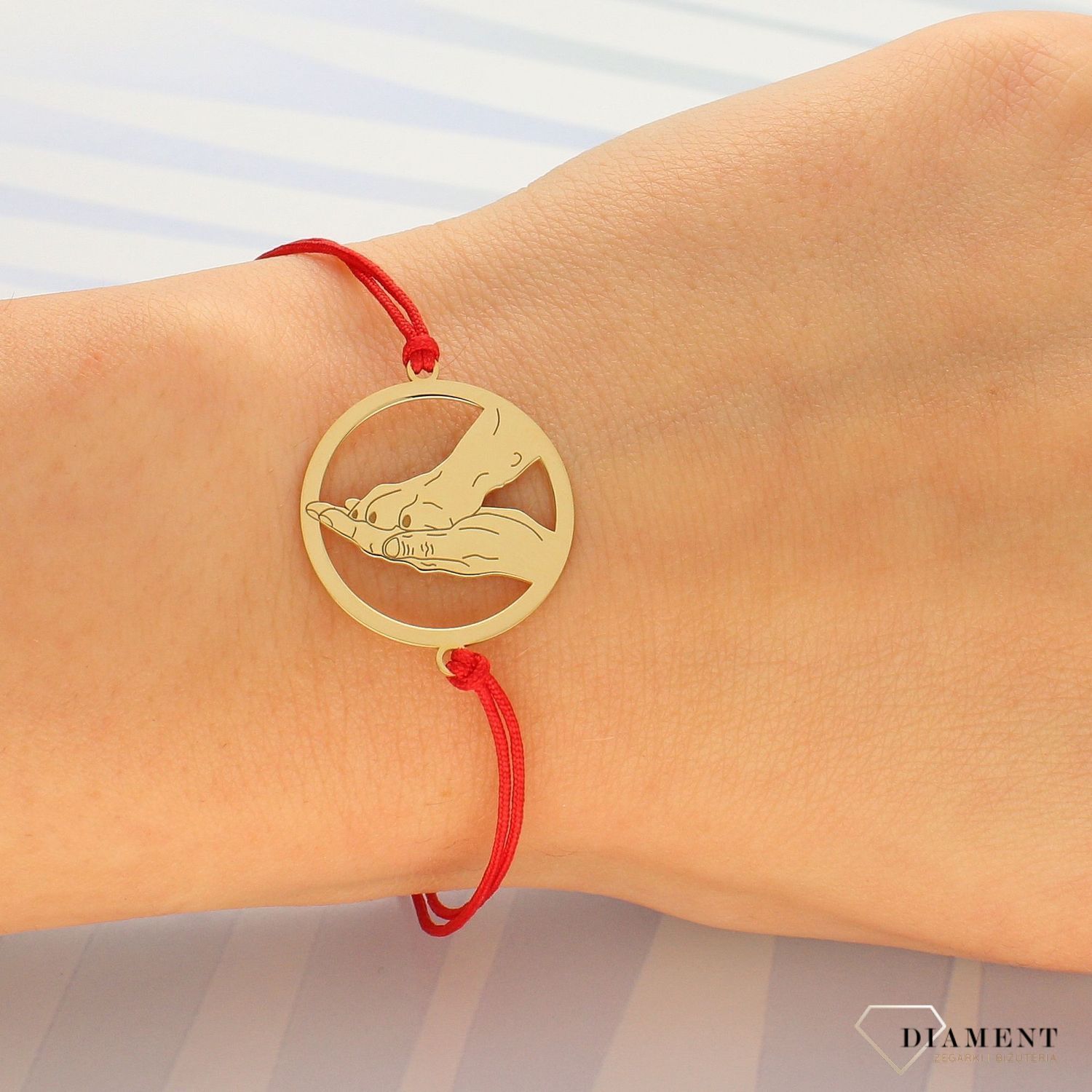 Bransoletka na czerwonym sznurku dłoń człowieka i psia łapka DIA-BRA-BR2 R385. Bransoletka na czerwonym sznurku z zawieszką przedstawiającą dłoń człowieka i łapę psa..jpg